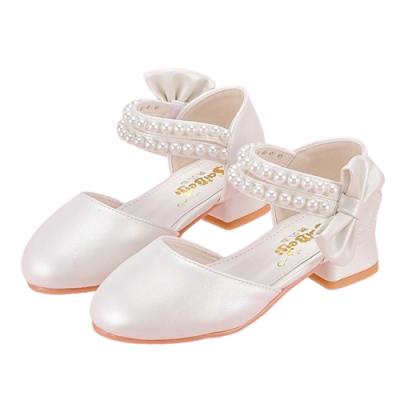 Białe perłowe pantofelki komunijne dla dziewczynki z ozdobnymi paskami z perełek oraz dużą kokardą na pięcie.