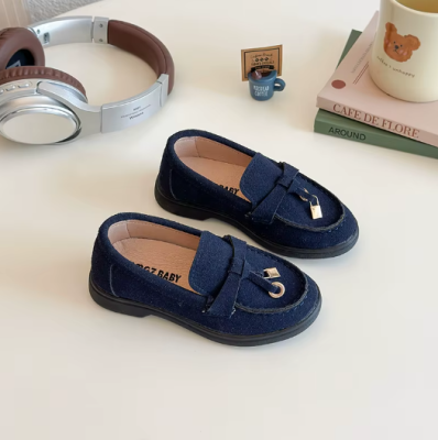 Zamszowe mokasyny dziecięce z ozdobnym złotym elementem, dostępne w kolorze beżowym, granatowym i brązowym.