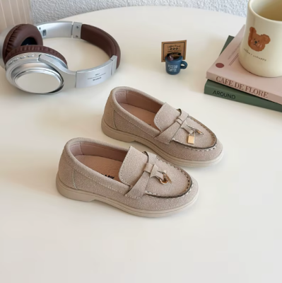 Zamszowe mokasyny dziecięce z ozdobnym złotym elementem, dostępne w kolorze beżowym, granatowym i brązowym.