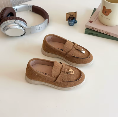 Zamszowe mokasyny dziecięce z ozdobnym złotym elementem, dostępne w kolorze beżowym, granatowym i brązowym.