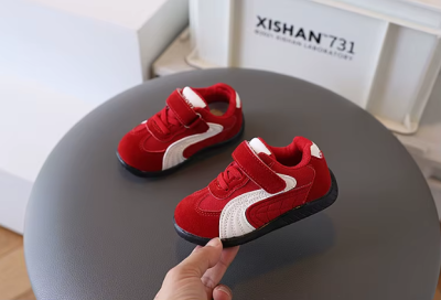 Zamszowe sneakersy dziecięce dla chłopca na rzepy, dostępne w kolorze czerwonym, czarnym i szarym z białymi detalami.