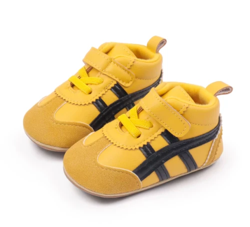 Sportowe sneakersy dla noworodka z miękką podeszwą i zapięciem na rzep, dostępne w kolorze żółtym, bordowym, czarnym i białym.