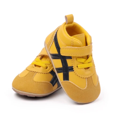Sportowe sneakersy dla noworodka z miękką podeszwą i zapięciem na rzep, dostępne w kolorze żółtym, bordowym, czarnym i białym.