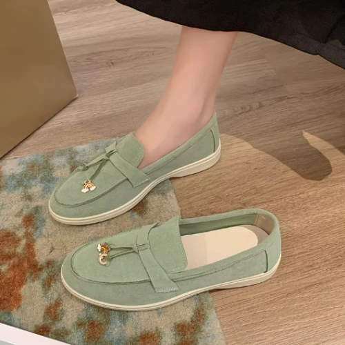 Zamszowe damskie lofersy na płaskiej, jasnej podeszwie z ozdobną przywieszką, dostępne w szerokiej gamie kolorystycznej.