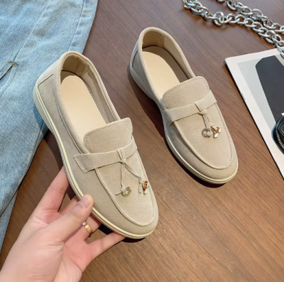 Zamszowe damskie lofersy na płaskiej, jasnej podeszwie z ozdobną przywieszką, dostępne w szerokiej gamie kolorystycznej.