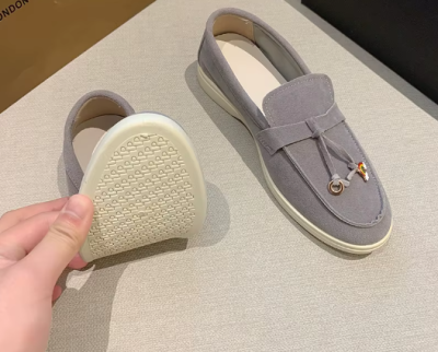 Zamszowe damskie lofersy na płaskiej, jasnej podeszwie z ozdobną przywieszką, dostępne w szerokiej gamie kolorystycznej.