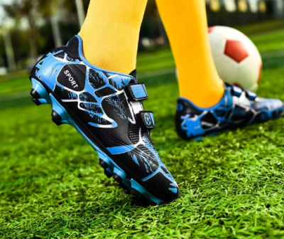 Dziecięce buty piłkarskie korki z dwoma paskami na rzepy i systemem kołków do gry na trawie.