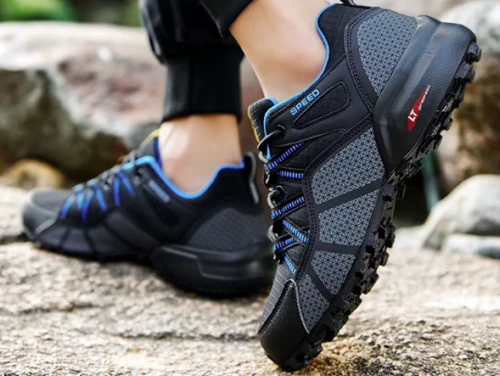 Męskie buty trekkingowe z dynamicznym wzorem bocznych pasów i traperową podeszwą, dostępne w kolorze czarnym i szarym z kolorowymi detalami w rozmiarach 39-47.