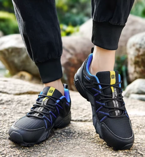 Męskie buty trekkingowe z dynamicznym wzorem bocznych pasów i traperową podeszwą, dostępne w kolorze czarnym i szarym z kolorowymi detalami w rozmiarach 39-47.