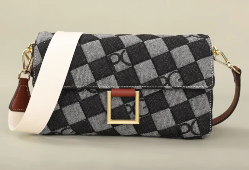 Elegancka torebka damska we wzór szachownicy z ozdobną złotą klamrą i rączką.